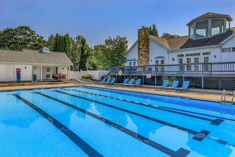 A large swimming pool with lane dividers and a building in the background.