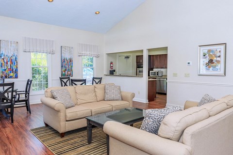 A living room with a beige couch and a glass coffee table.