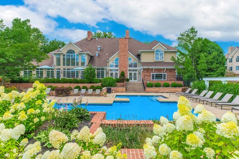A large house with a pool and a garden in front.