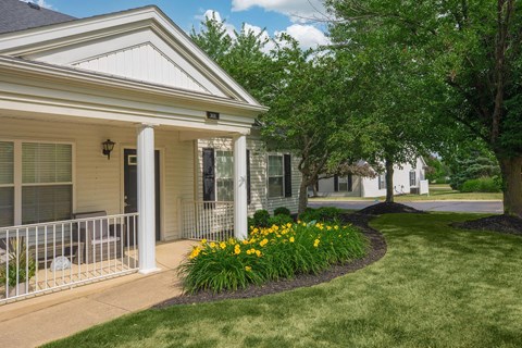 a house with a porch and a yard with flowers