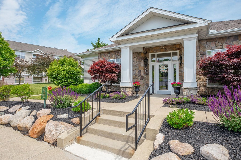 the front of a house with stairs and a landscaped front yard