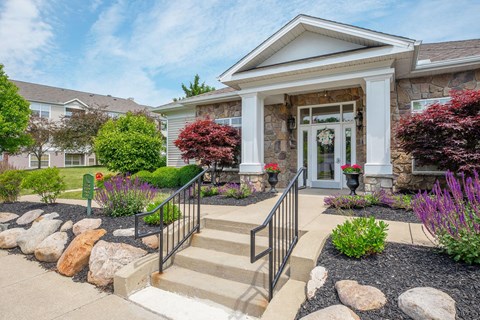 the front of a house with stairs and a landscaped front yard