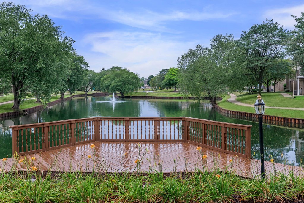 a view of a pond with a wooden deck