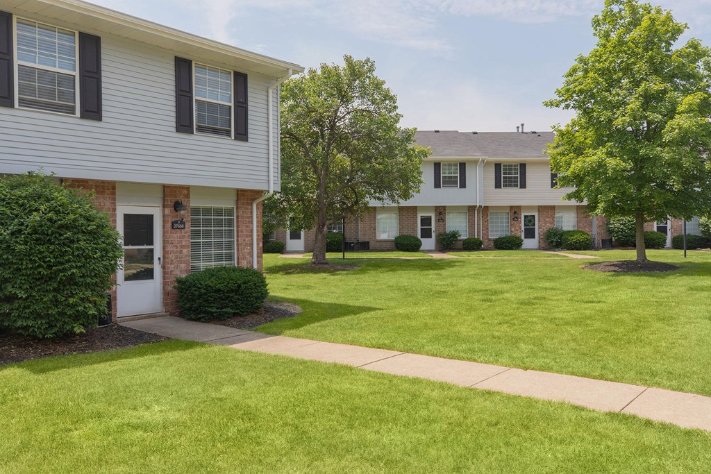 A white house with a green lawn in front.
