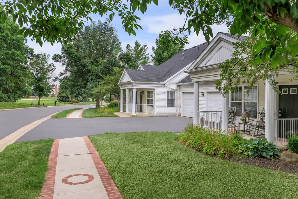 a white house with a driveway and a sidewalk in front of it