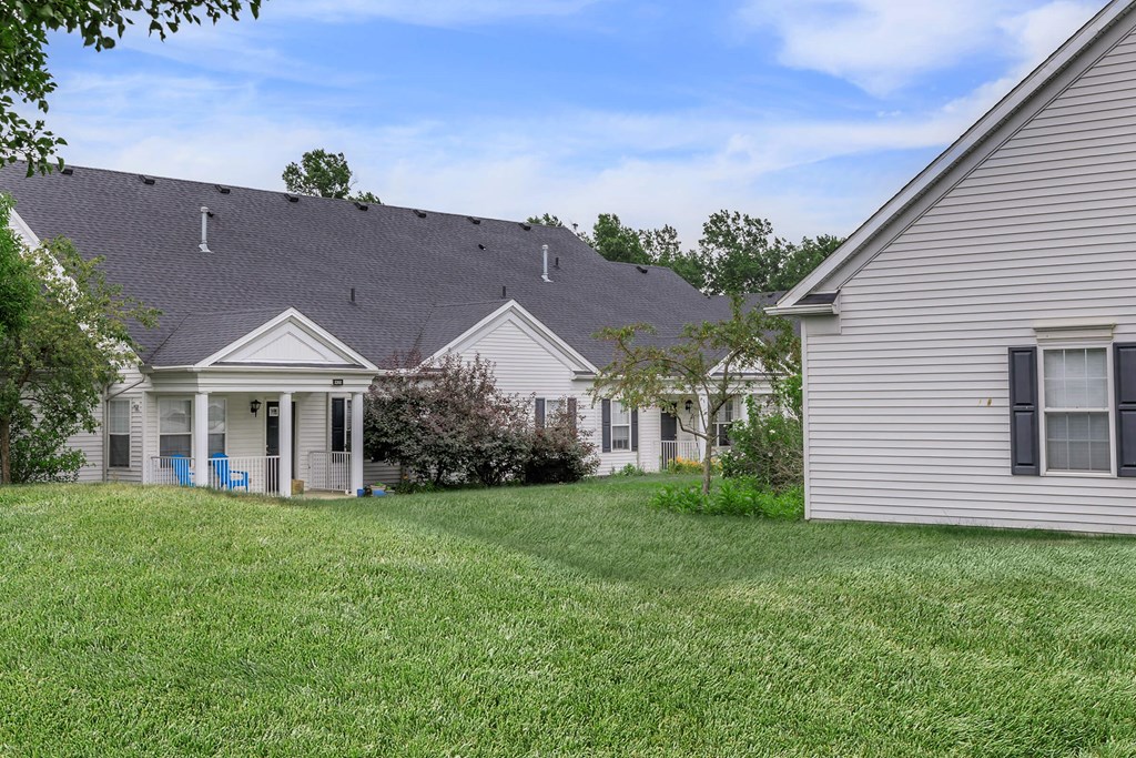 the backyard of a house with a yard in front of it
