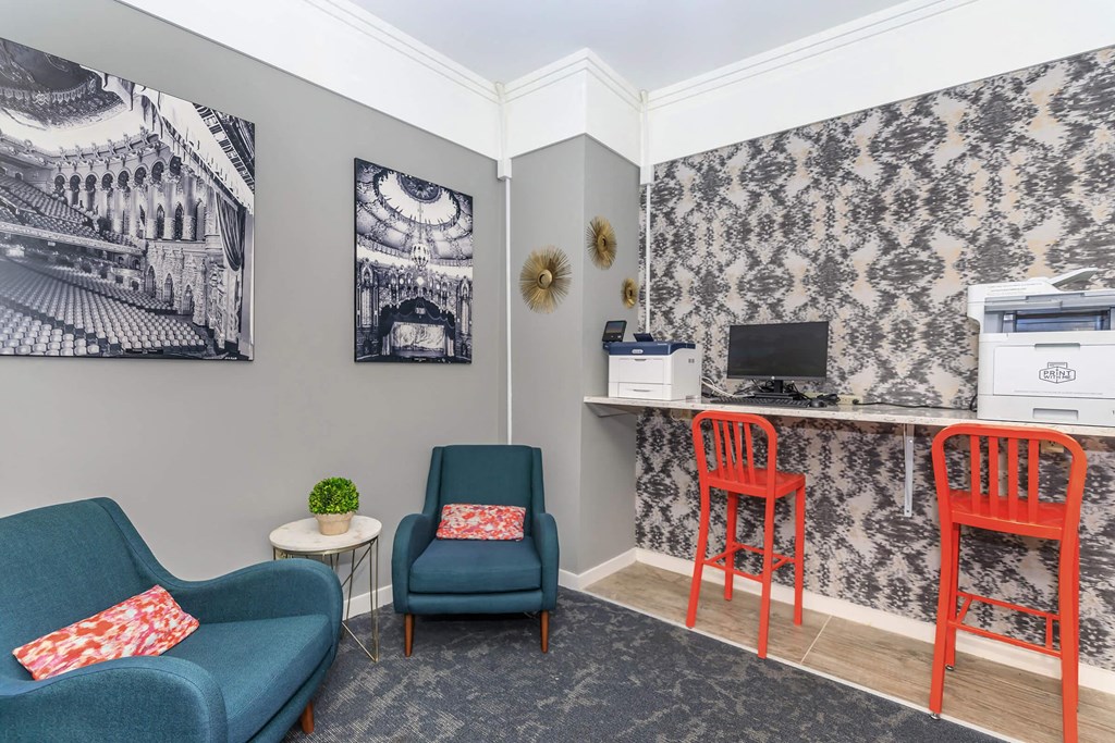 a living room with two chairs and a desk with a computer