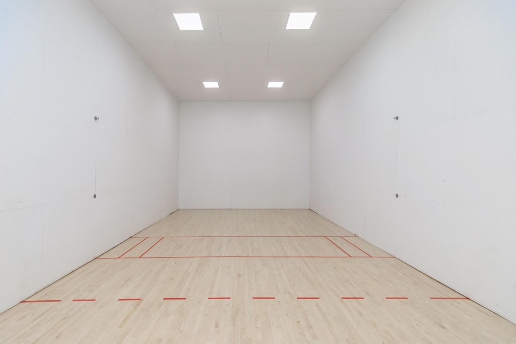 a white room with a racquetball court and a red