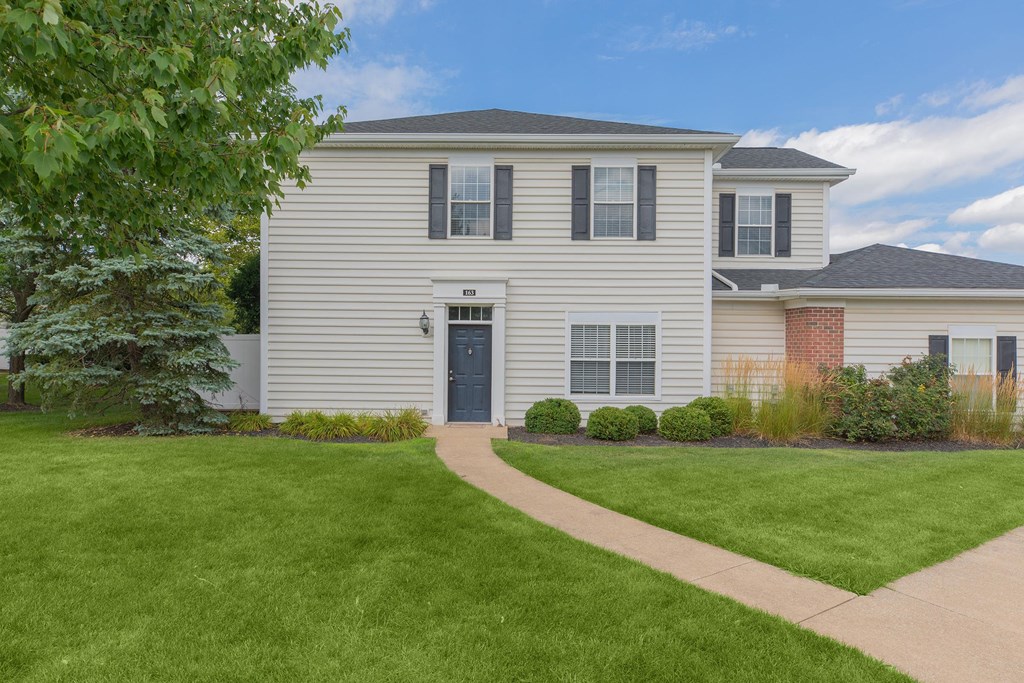 a white house with a sidewalk in front of it