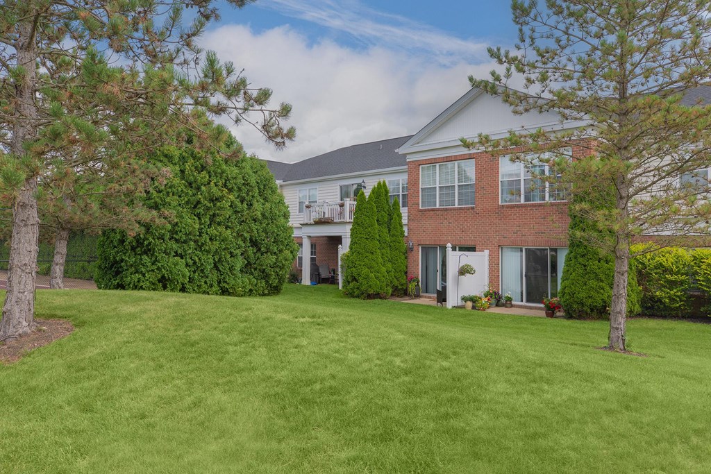 a house with a lawn and trees in front of it