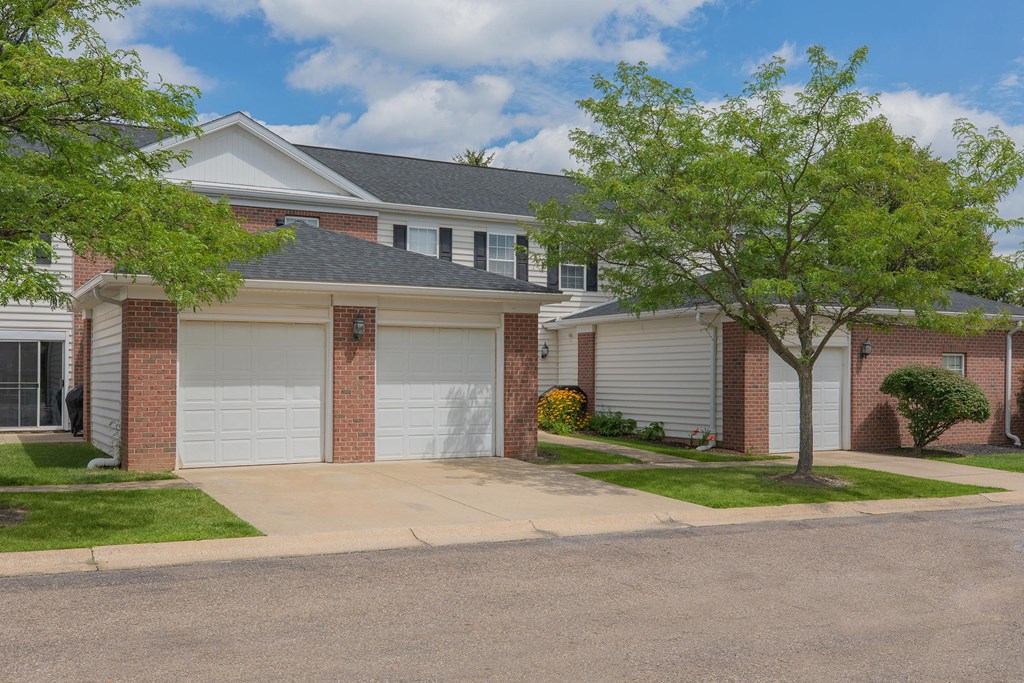 a house with two garage doors and a sidewalk in front of it