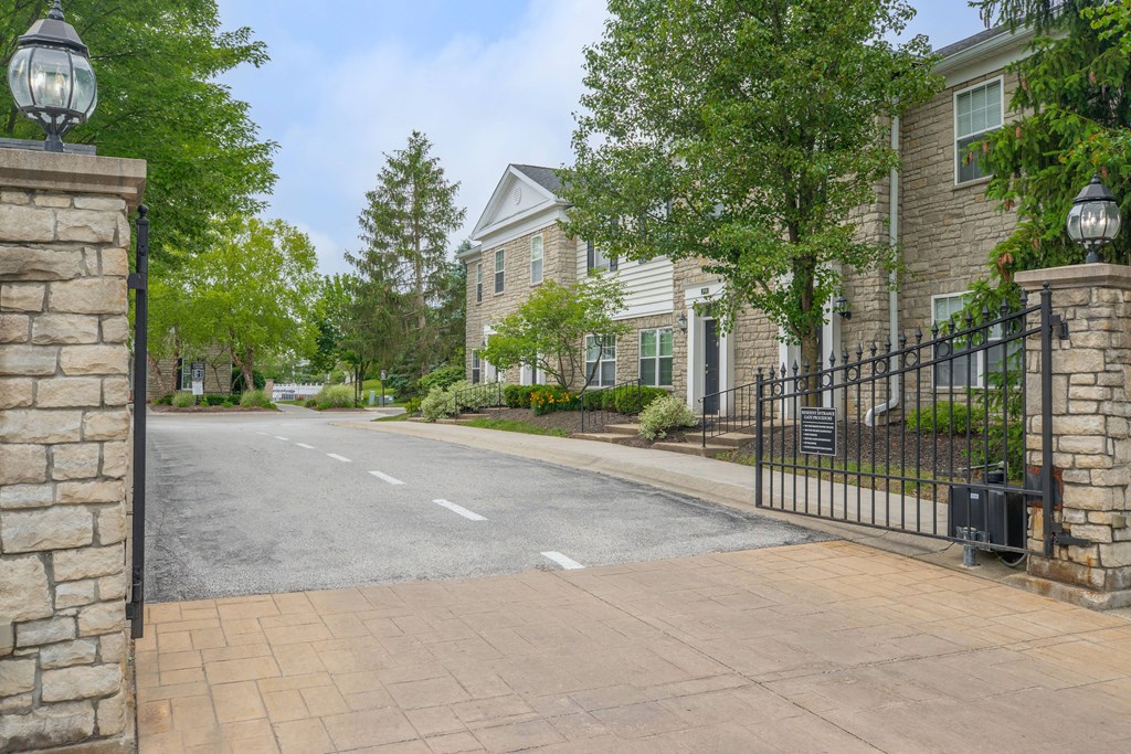 the front of a house with a driveway and a gate