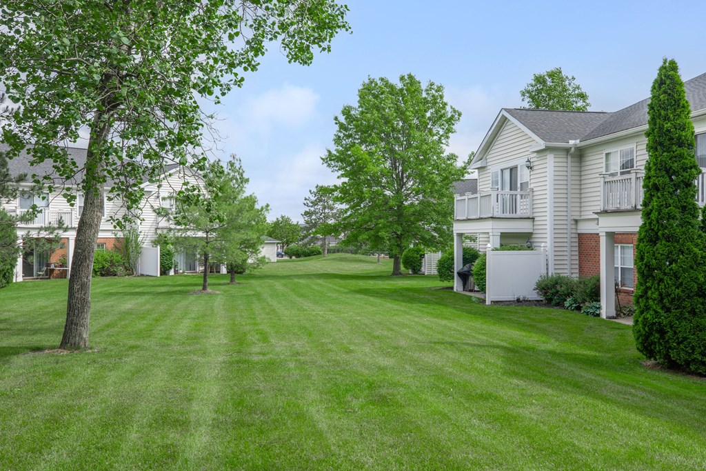 a green lawn in front of a white house