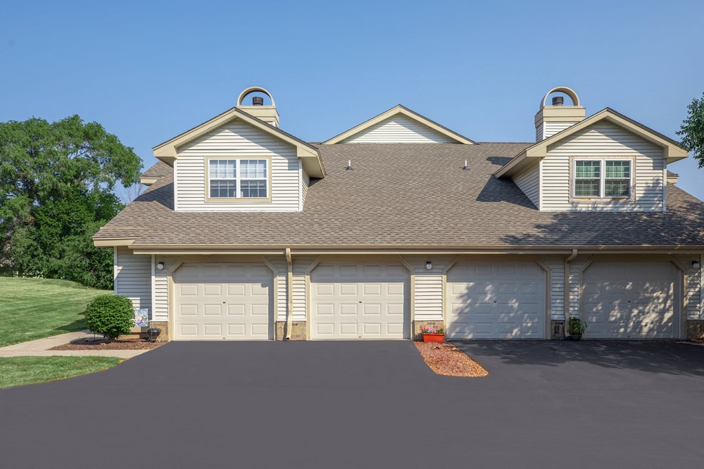a white house with two garage doors and a driveway