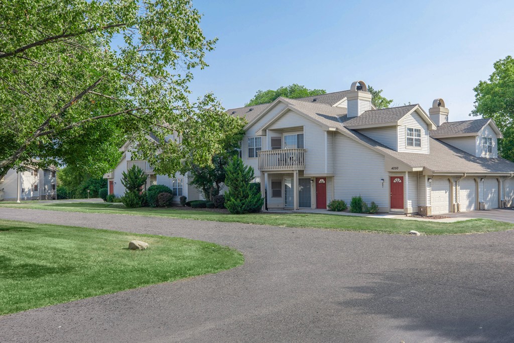 a white house with a red door and a yard