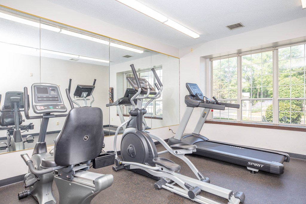 the gym has plenty of exercise equipment and a large window