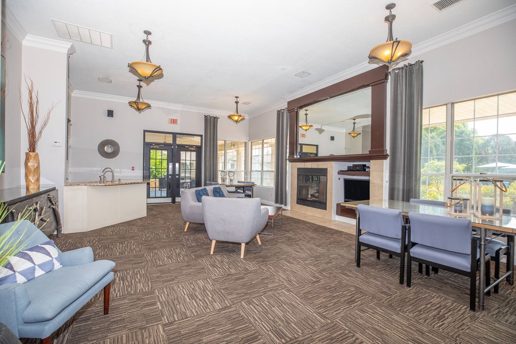 a living room with couches chairs and a table and a fireplace
