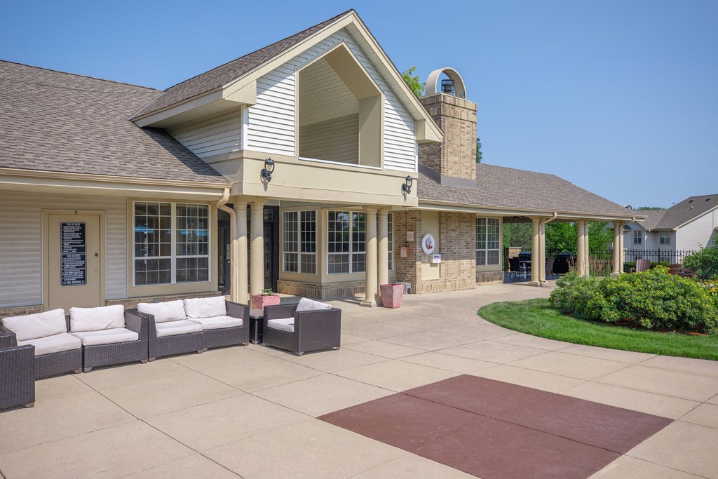 a patio in front of a house with furniture on it
