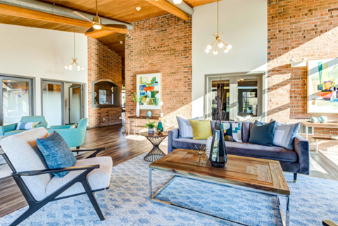 A living room with a blue rug and a wooden coffee table.