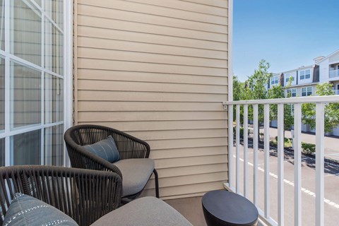 a balcony with two chairs and a table on a balcony