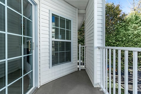 a porch of a home with white siding and a large window
