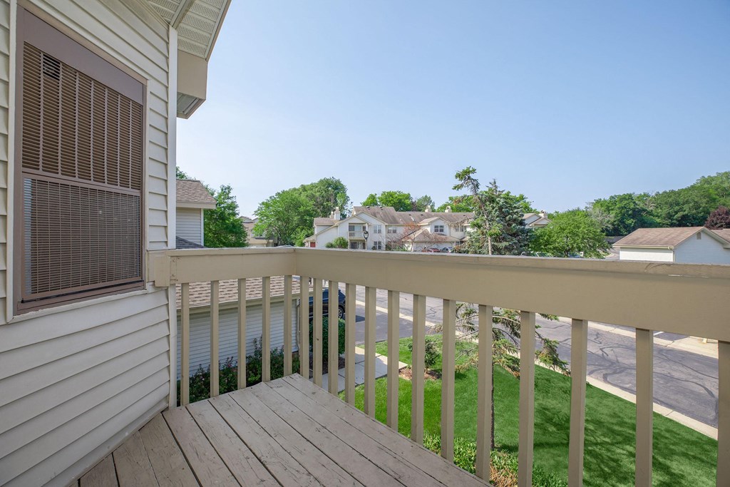 a balcony with a view of a yard and a house