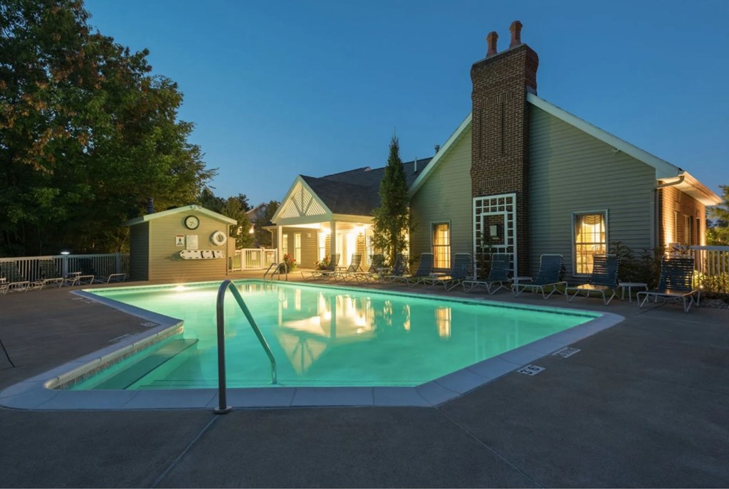 A house with a pool in front of it.