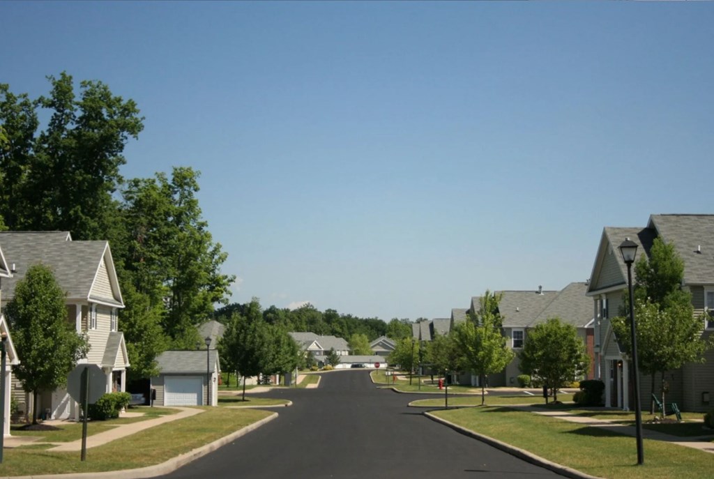 A street in a residential neighborhood with houses on both sides.