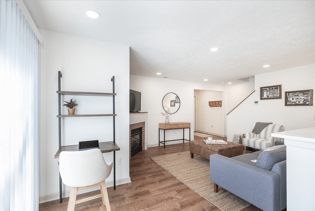 A living room with a grey couch and a white chair.