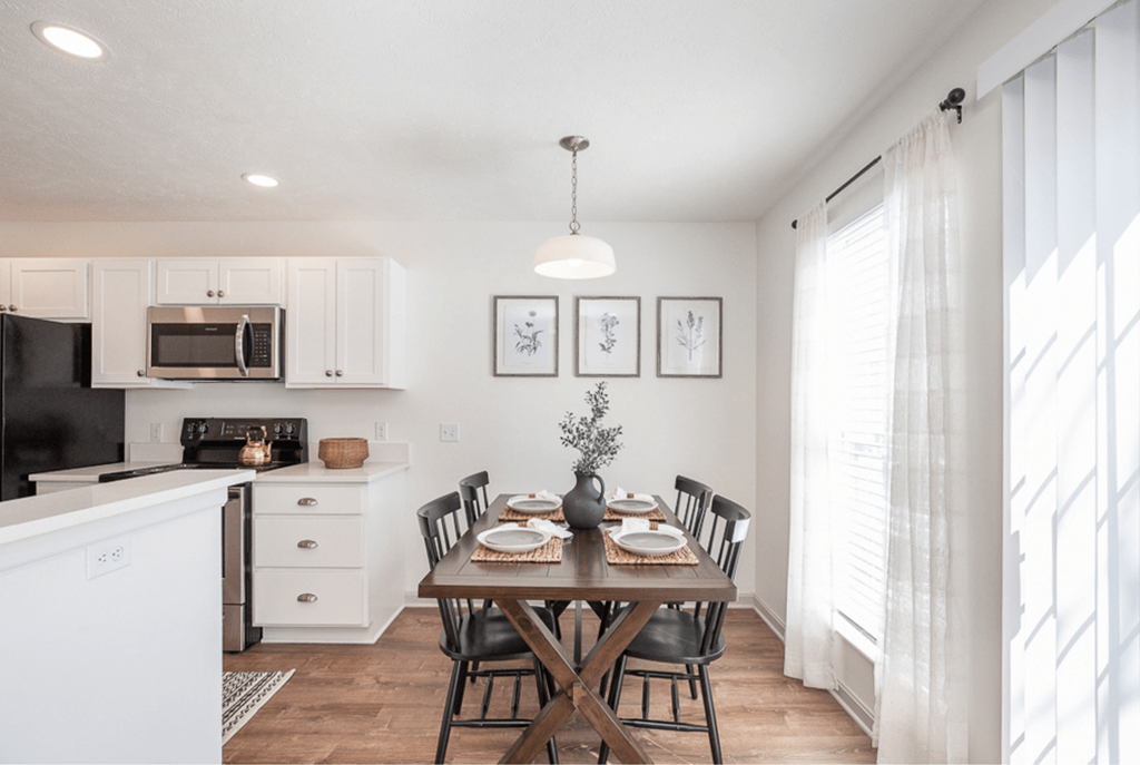 A dining room with a table set for a meal.