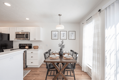 A dining room with a table set for a meal.