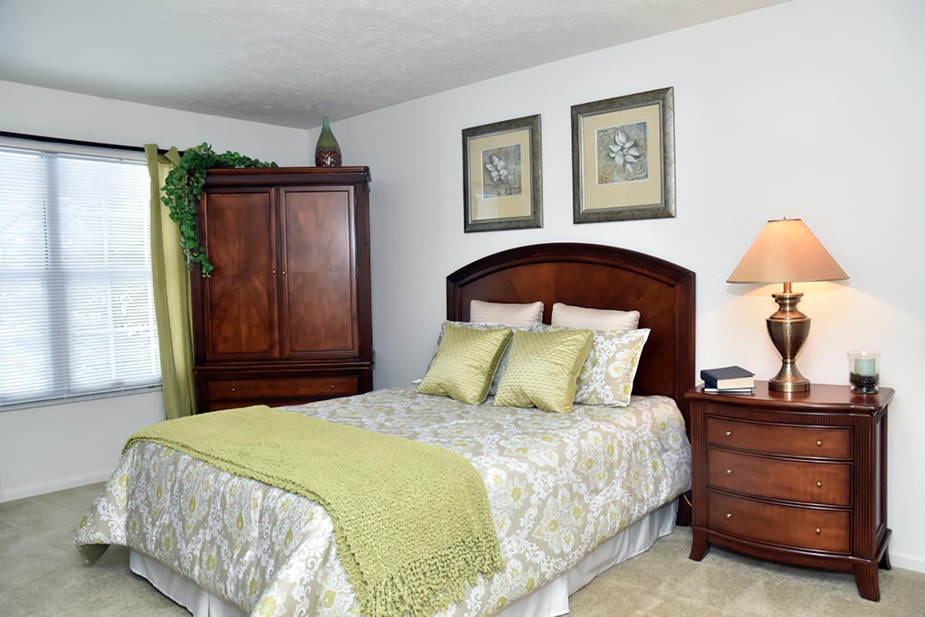 a bedroom with a bed and a dresser and a window