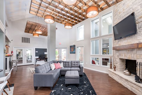 A modern living room with a grey couch and a fireplace.