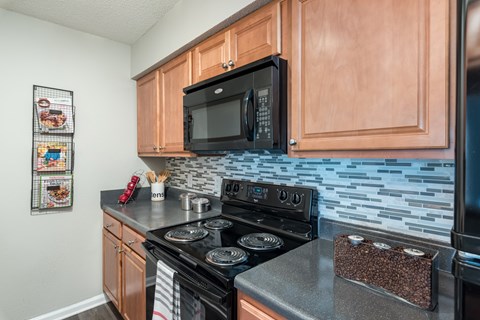A kitchen with a black microwave above a black stove.