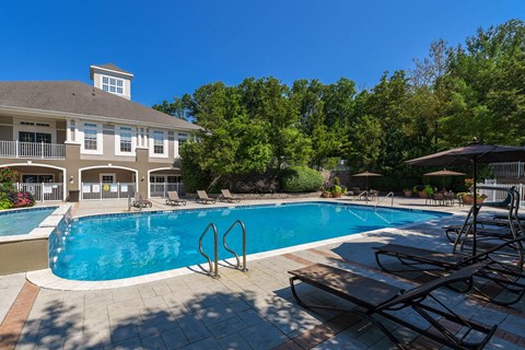 a swimming pool in front of a large house with a resort style pool
