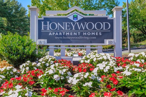 a sign apartment homes with red and white flowers