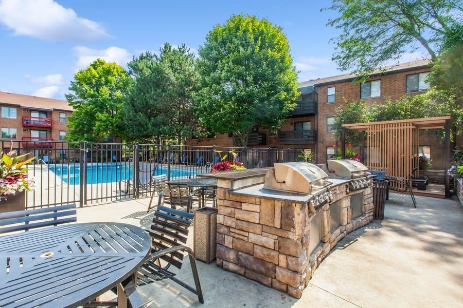 A patio with a table, chairs, and a pool.