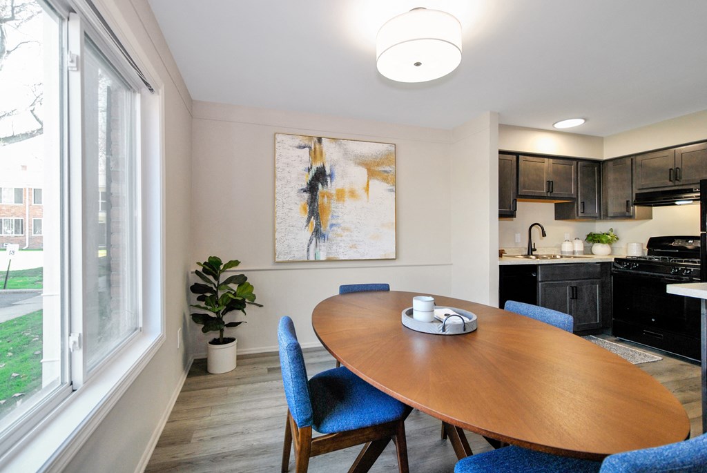 A dining room with a wooden table and blue chairs.