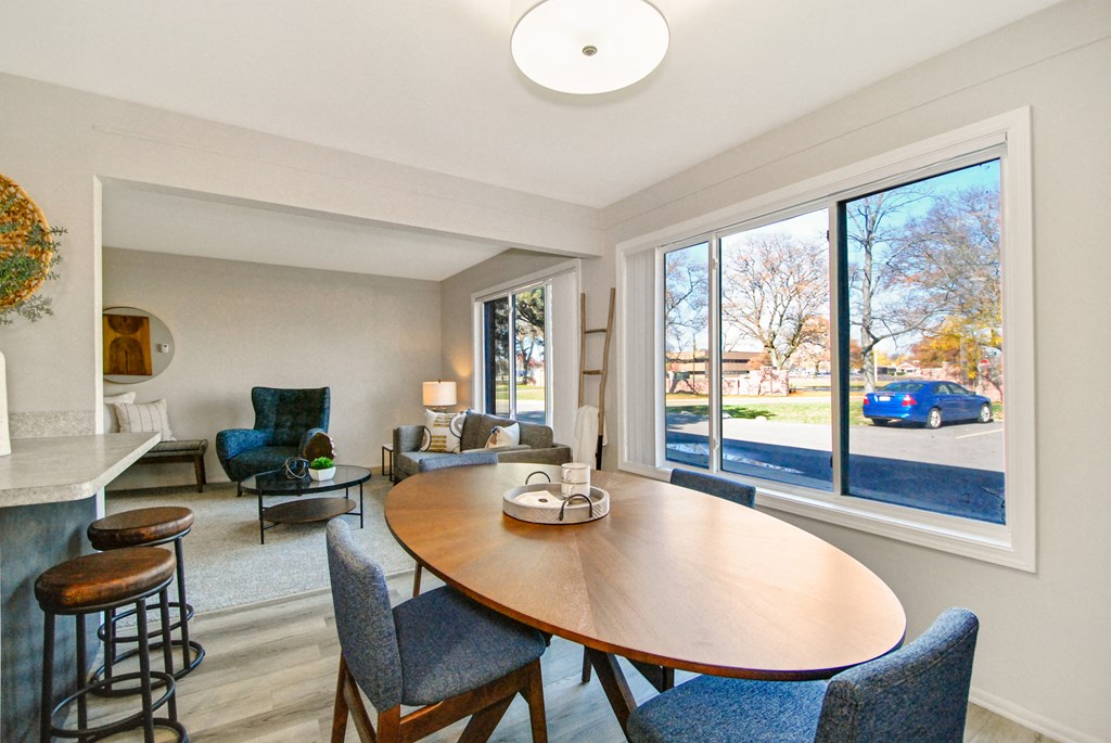 A dining room with a wooden table and chairs.
