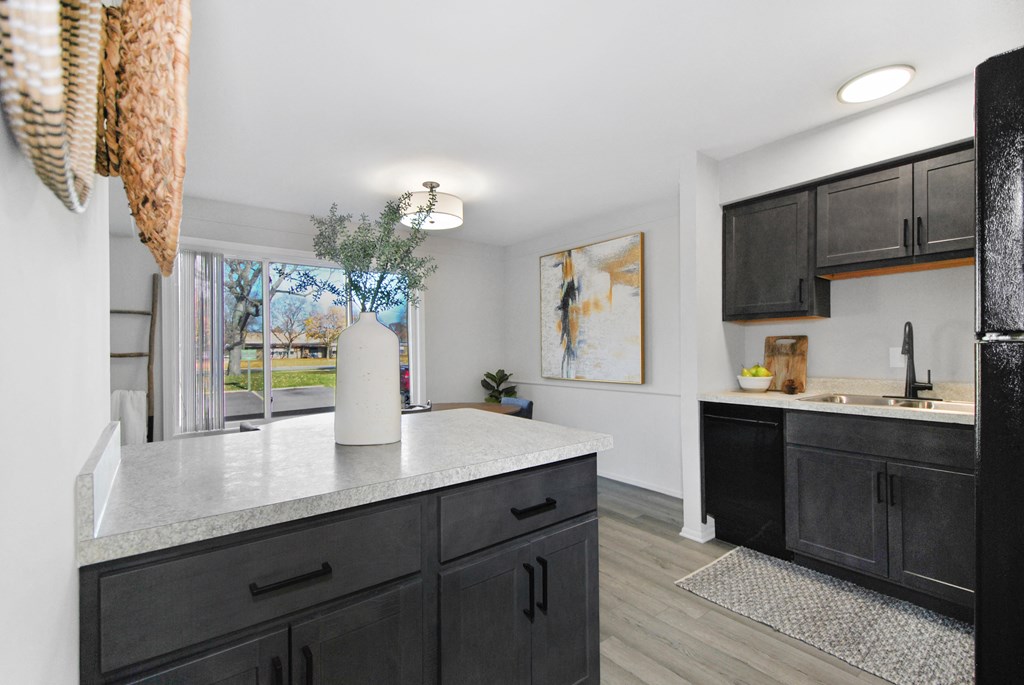 A kitchen with black cabinets and a white countertop.