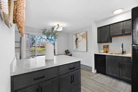 A kitchen with black cabinets and a white countertop.