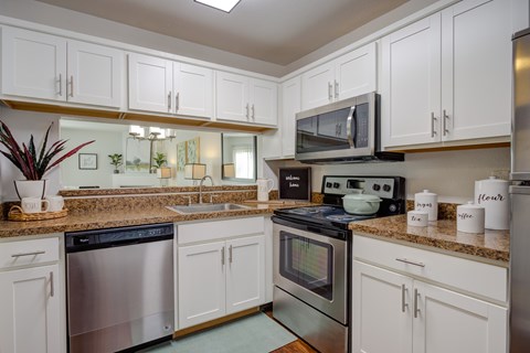 A kitchen with white cabinets and stainless steel appliances.