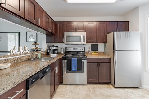 A kitchen with brown cabinets and a black stove top oven.