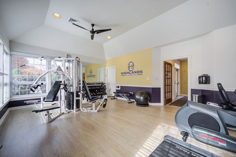 A gym with a variety of equipment including a treadmill, rowing machine, and weights at Highlands at Warwick Apartments, Lilitz, PA