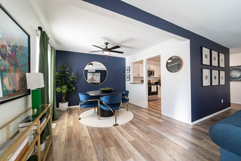 A living room with a blue couch and a ceiling fan.