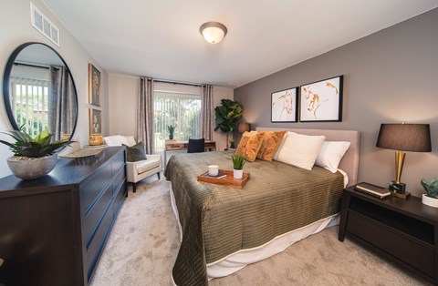 A bedroom with a large bed and a dresser.