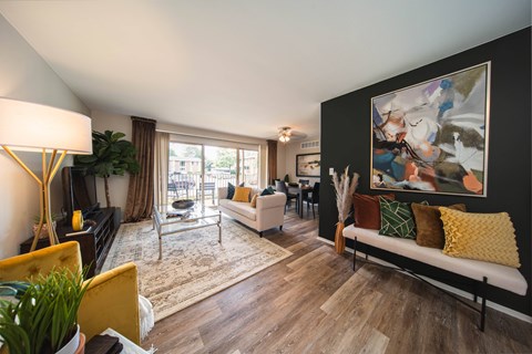A living room with a yellow chair and a white couch.