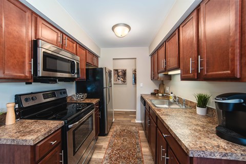 A kitchen with dark wood cabinets and granite countertops.