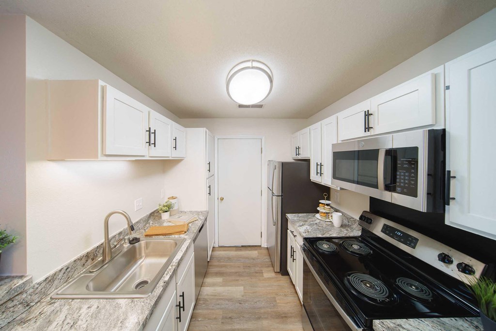 a kitchen with stainless steel appliances and white cabinets