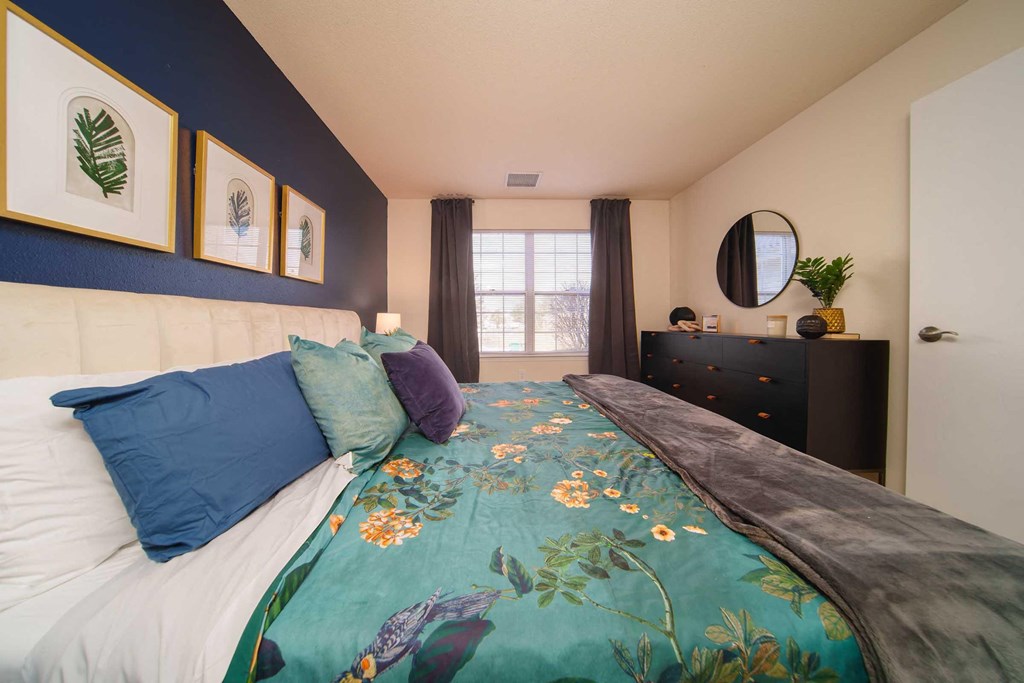 a bedroom with a bed and a blue wall and a window